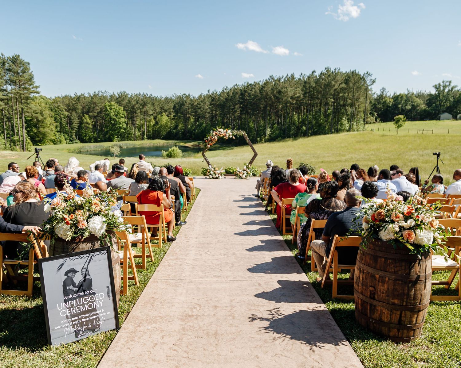 Outdoor wedding ceremony setup with wooden chairs and a stone pathway in a scenic garden setting.