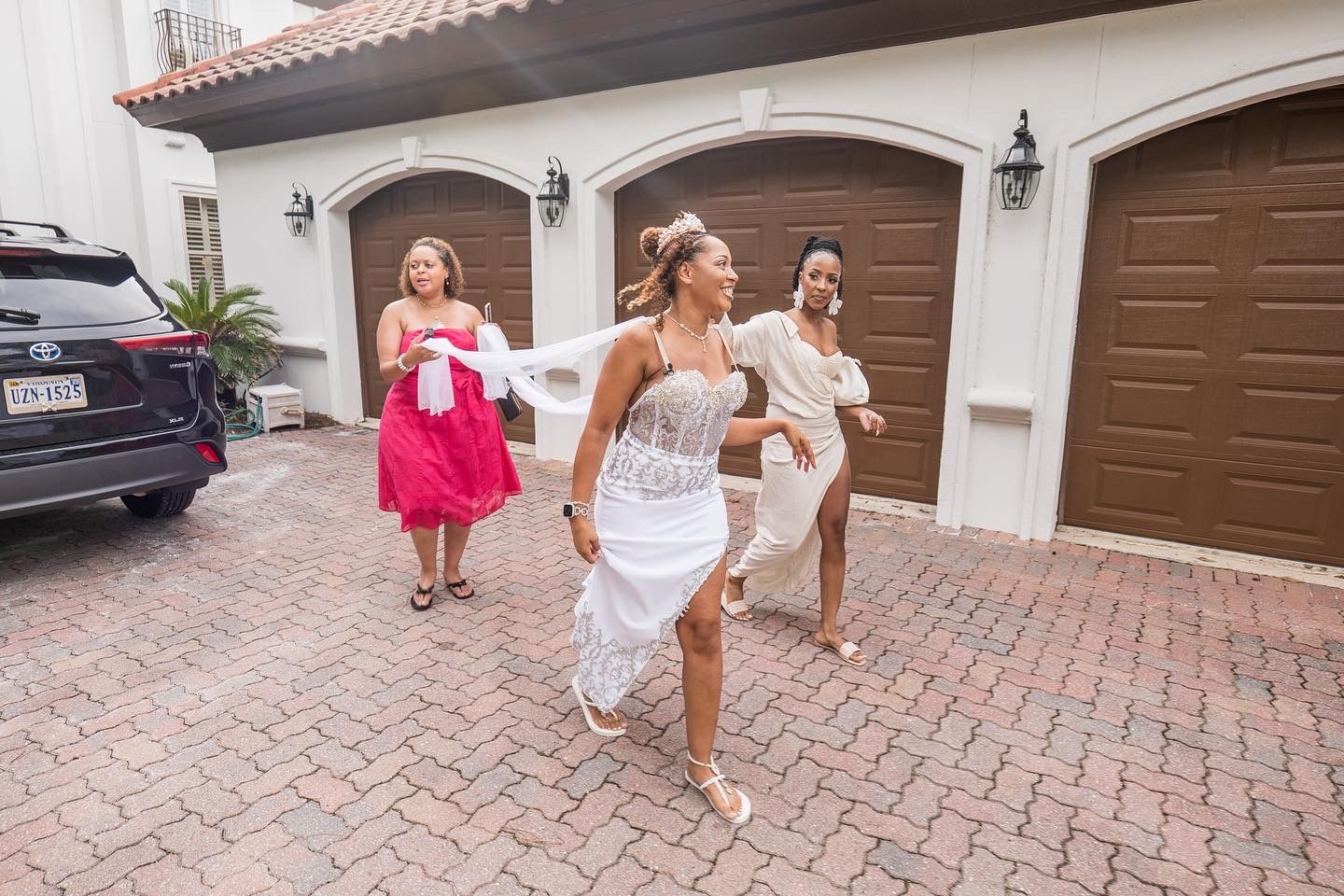 Walking scene outside Spanish-style homes with brown garage doors and brick driveway.