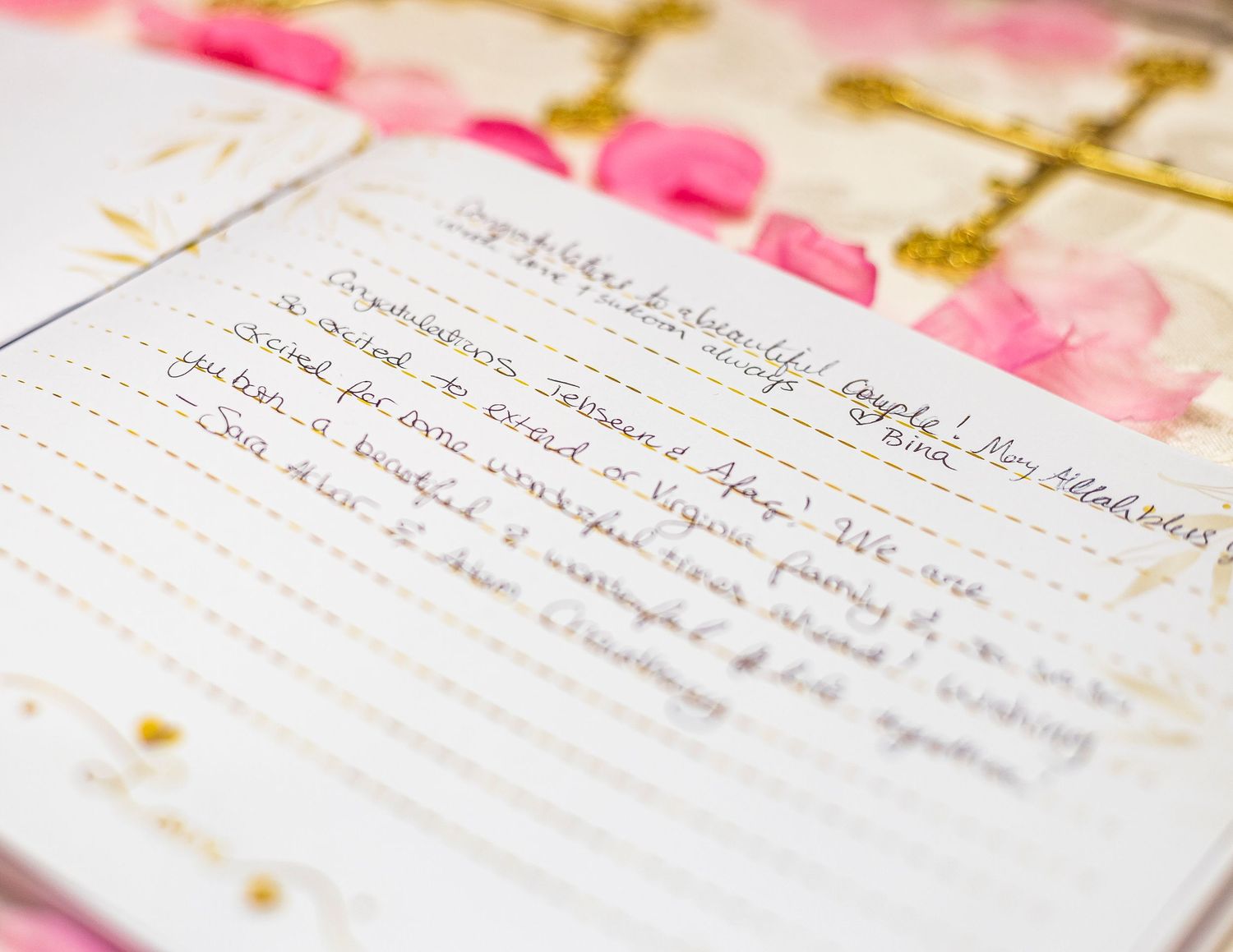 Open journal with handwritten notes on floral watercolor pages, featuring gold accents and pink rose details.