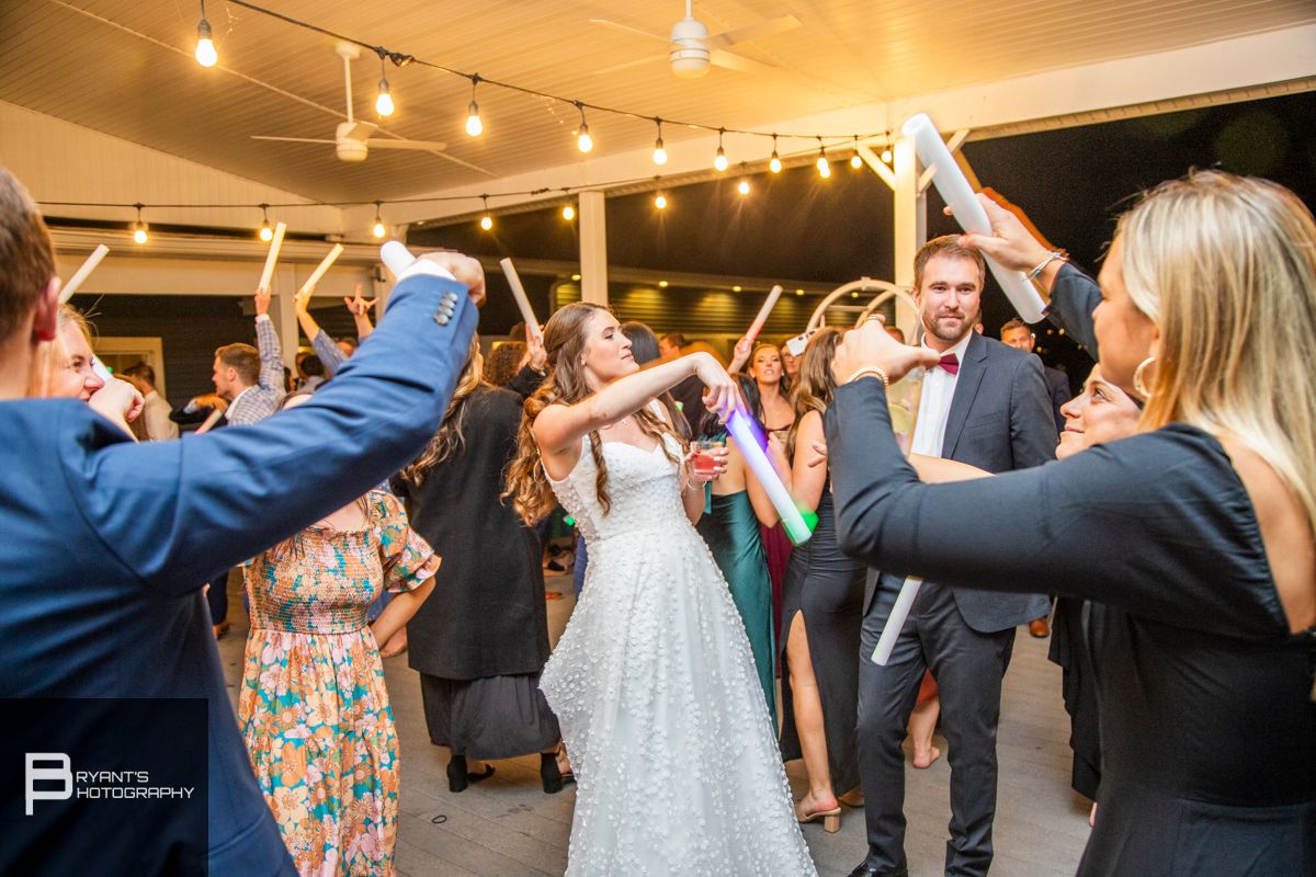 Wedding reception dance floor filled with celebrating guests under string lights.