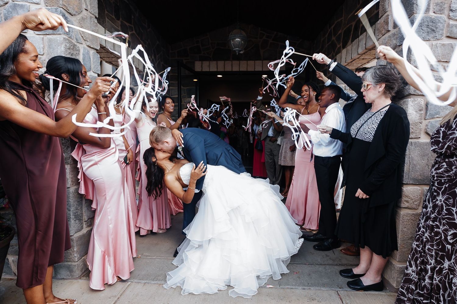 Wedding party celebrating with streamers during grand exit.