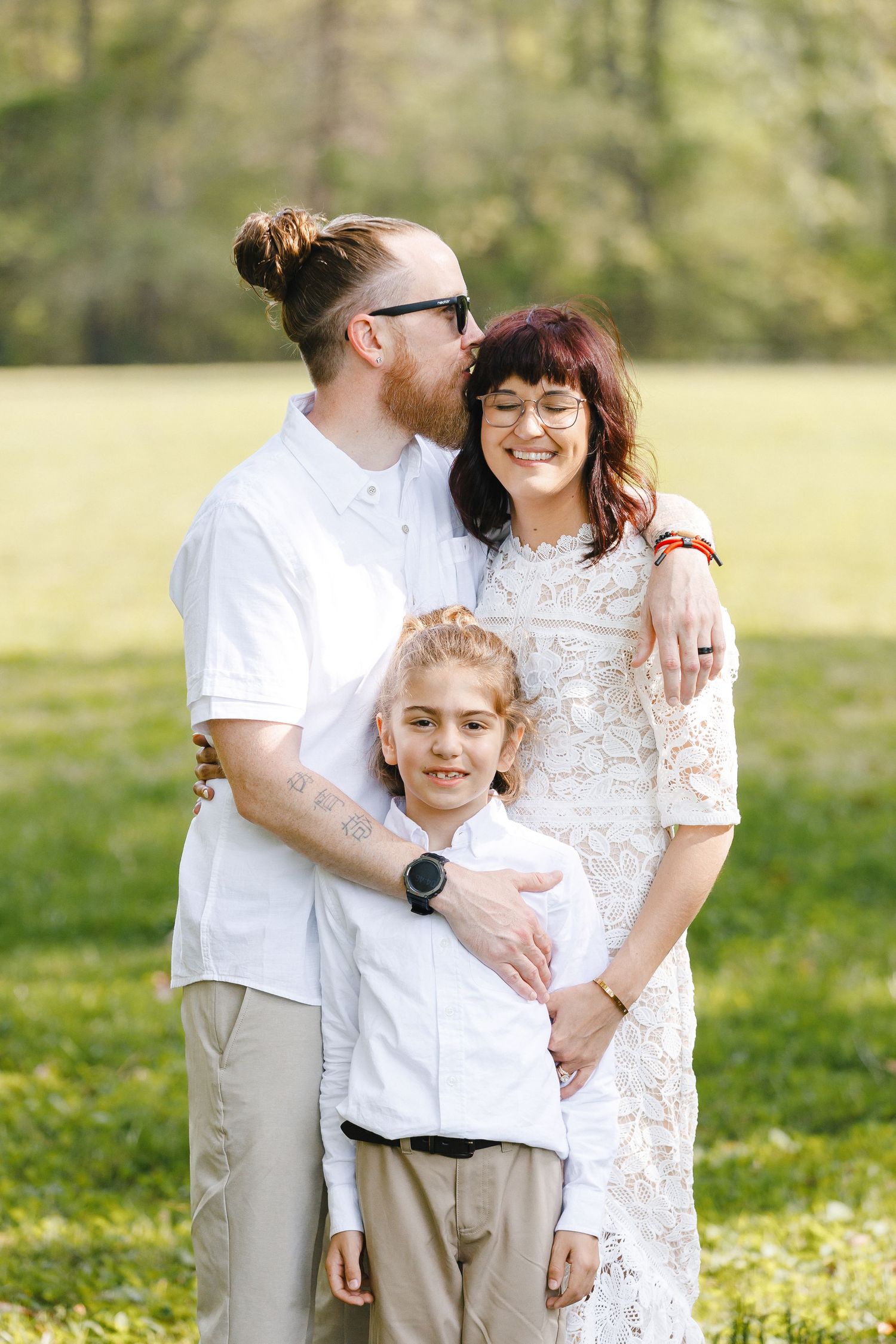 Family portrait session outdoors in coordinated white outfits.