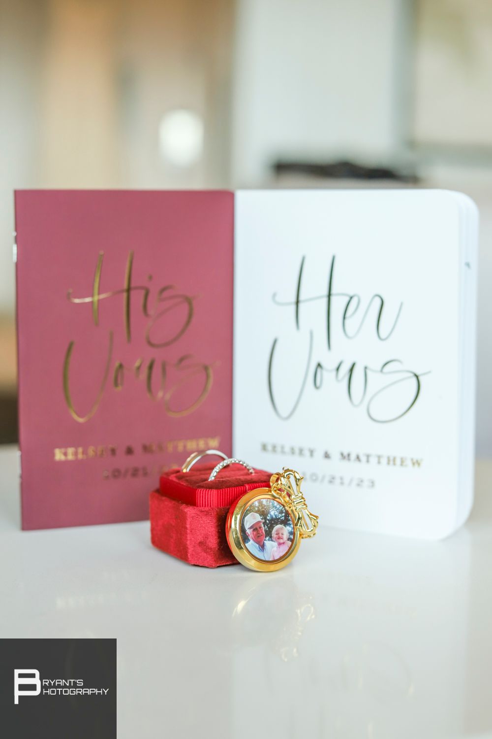 Wedding rings and engagement ring displayed with pink and white name cards at an elegant reception setup.