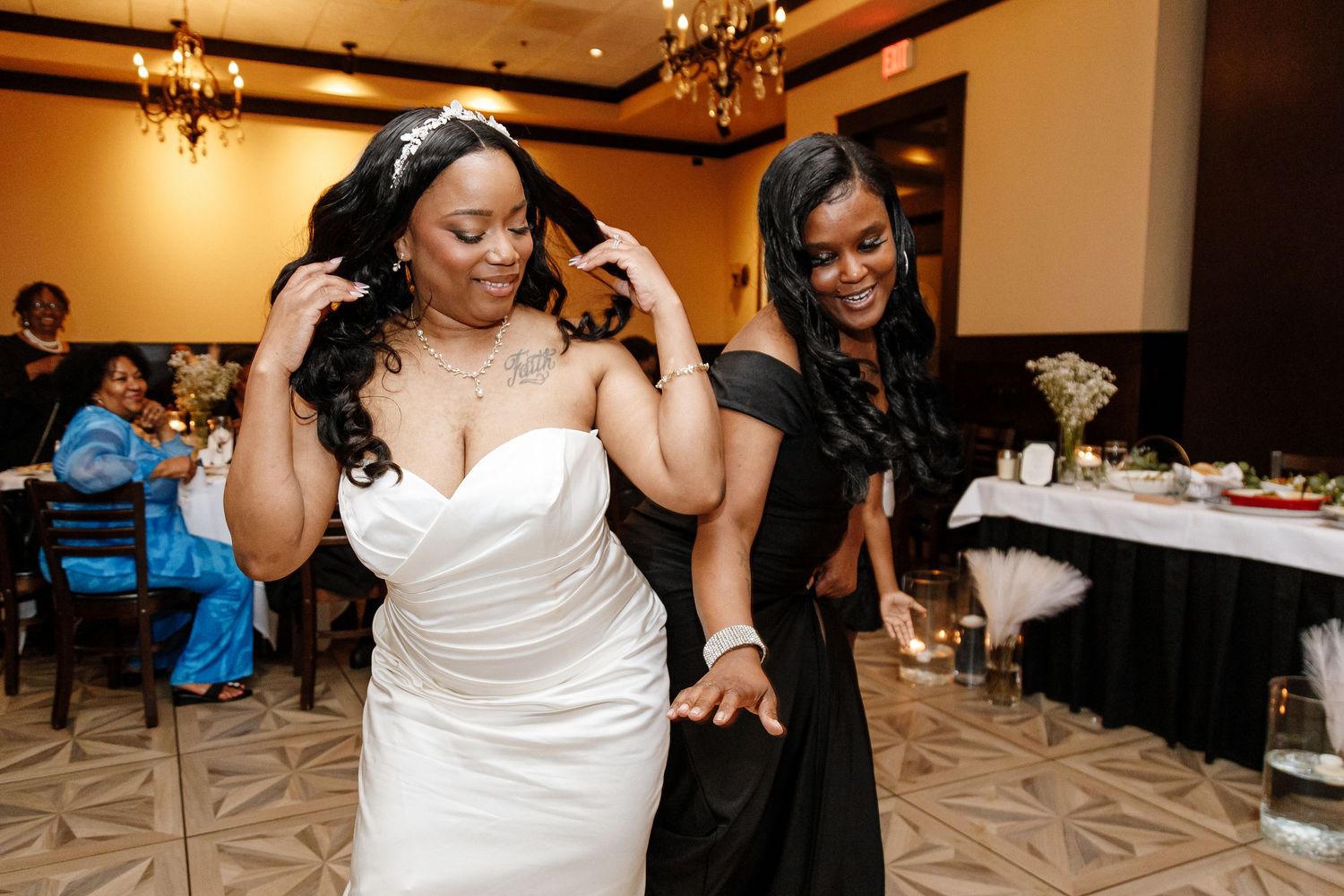 Wedding reception celebration in an elegant ballroom with chandeliers and formal table settings.