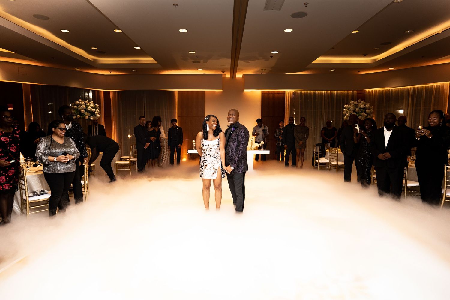 Wedding reception dance floor filled with fog effects and ambient lighting.