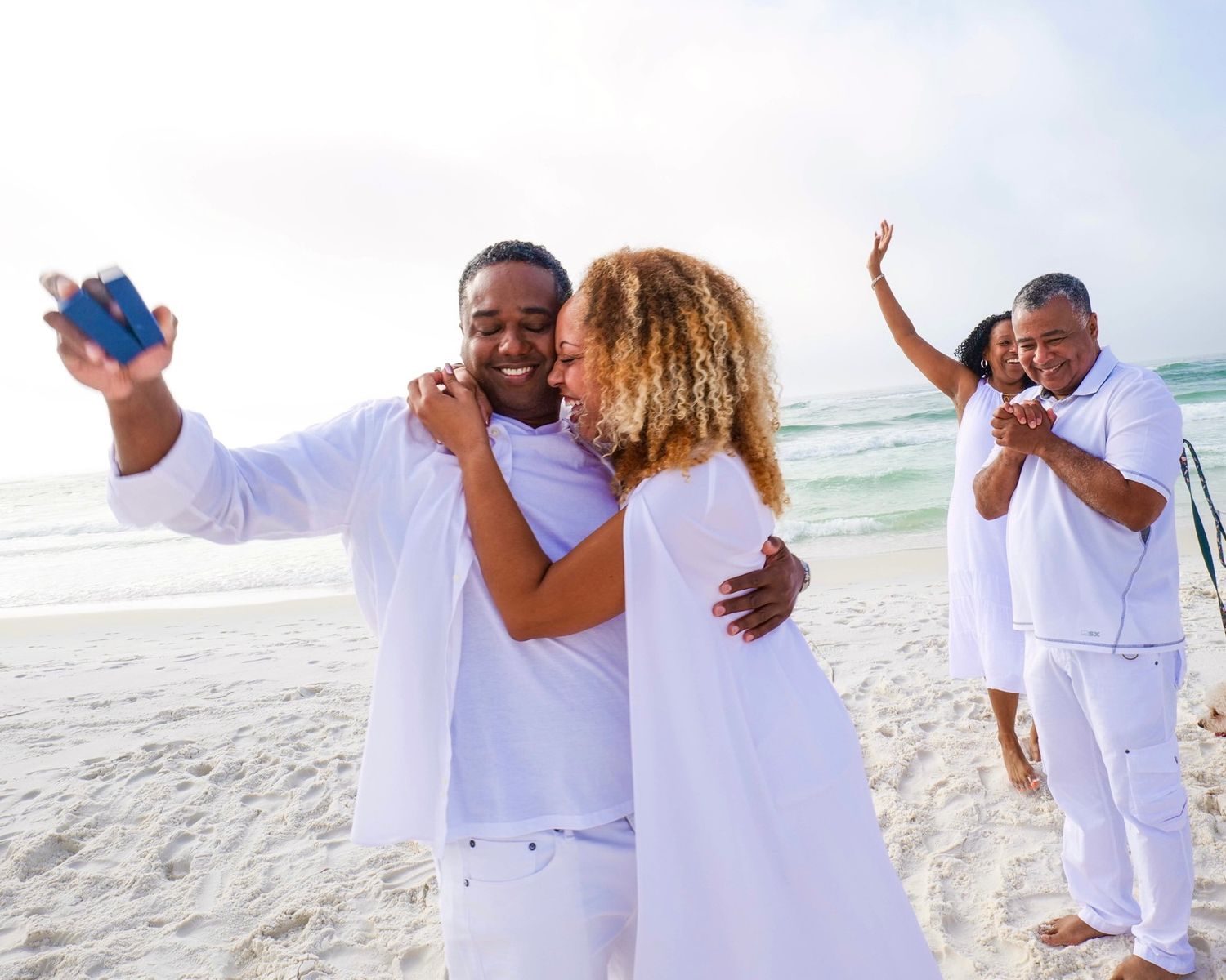 A joyful celebration moment on a beach after a proposal.