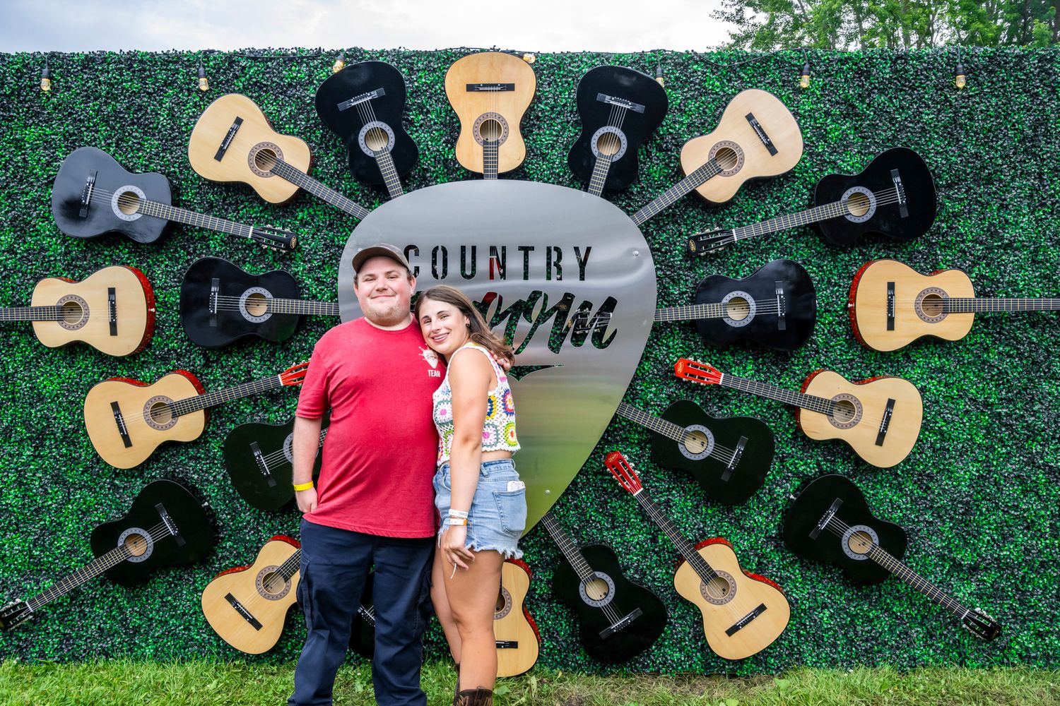 Decorative guitar display wall with black and wooden guitars arranged in a circle pattern.