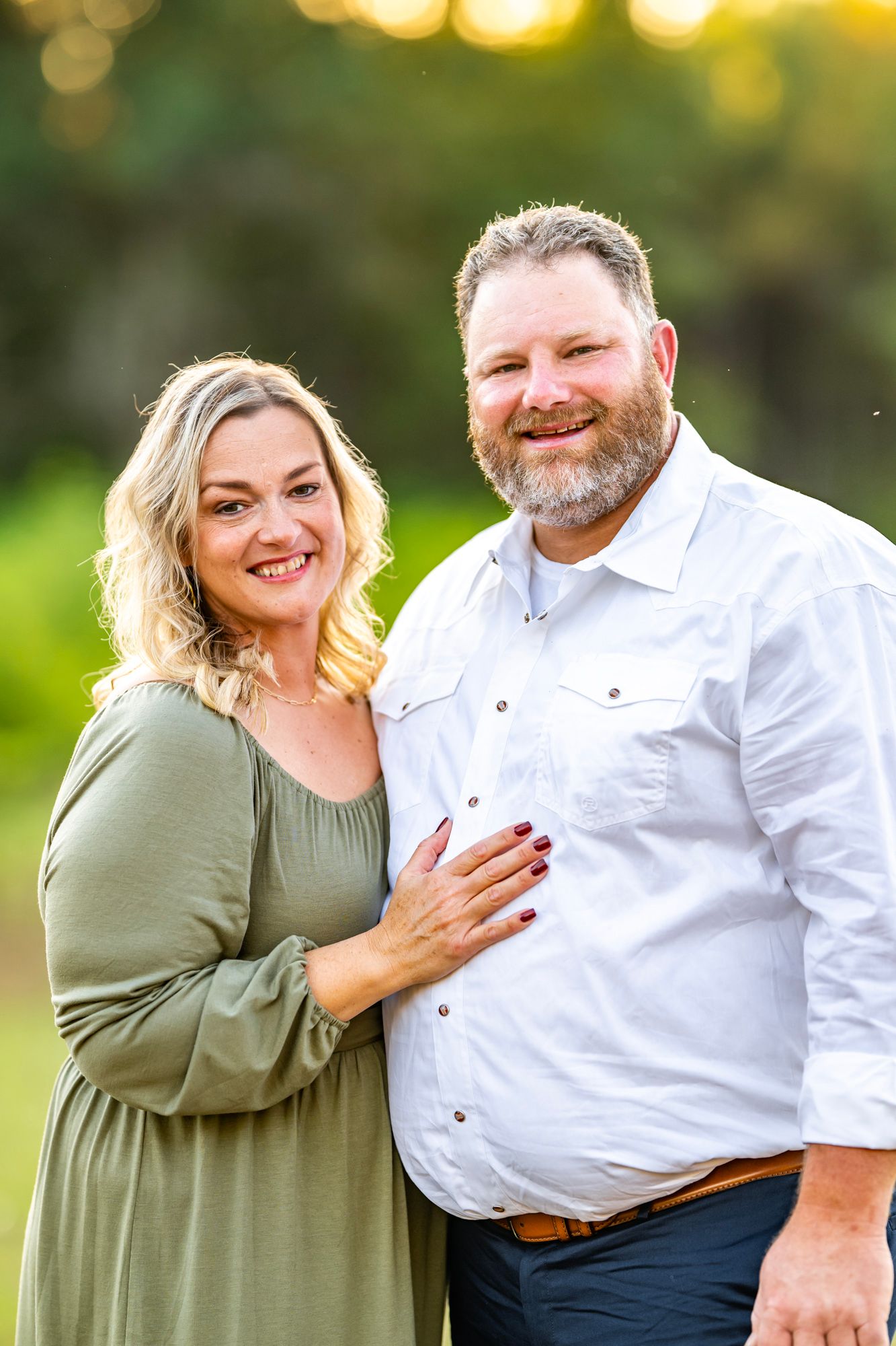 Candid engagement photos showing joyful laughter and embraces in golden evening light.