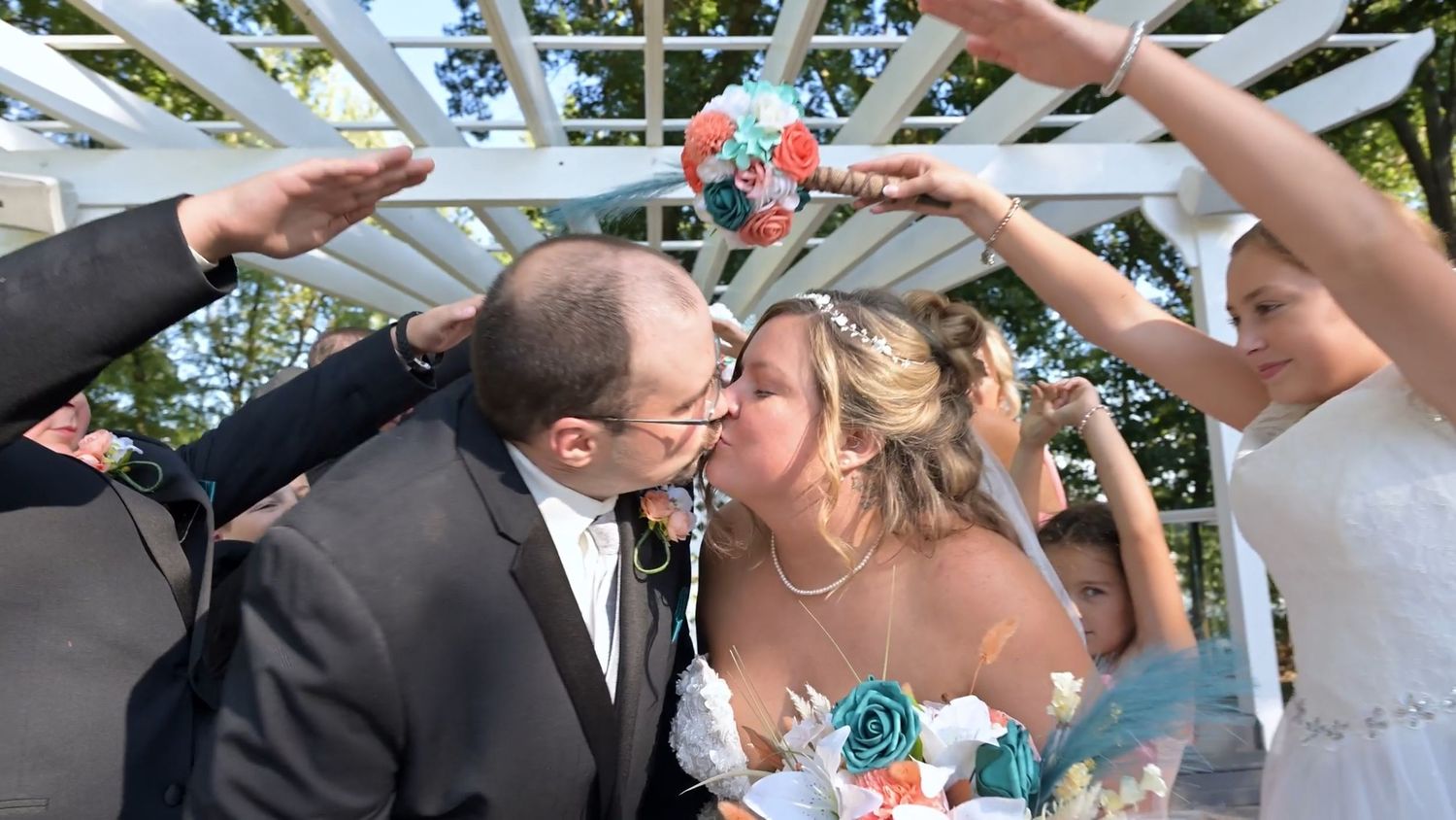 Wedding celebration moment with guests forming an arch with their arms.