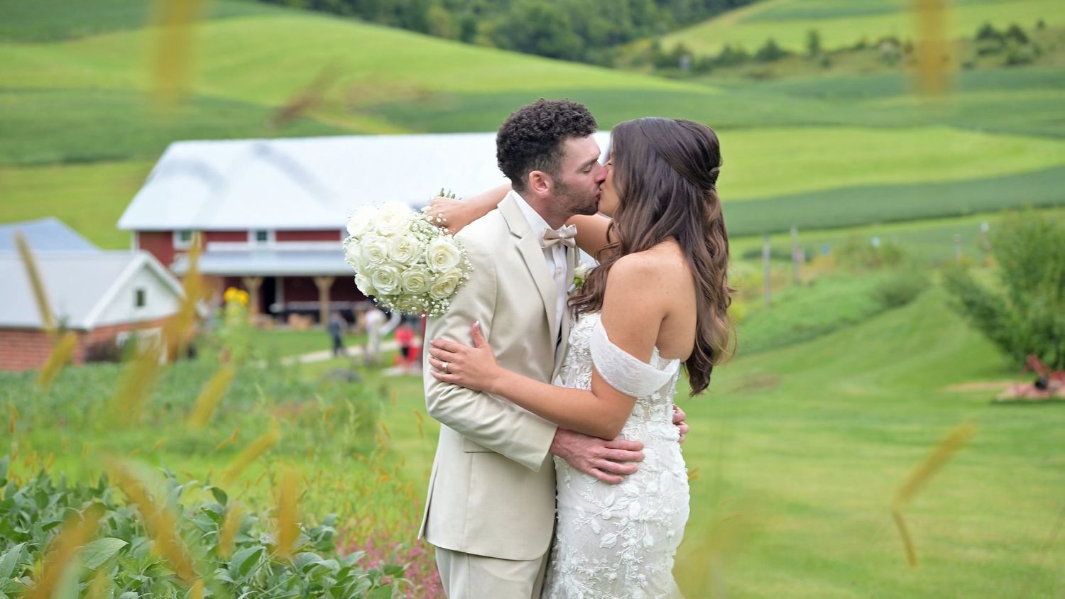 Romantic moment between newlyweds on rolling green golf course landscape.