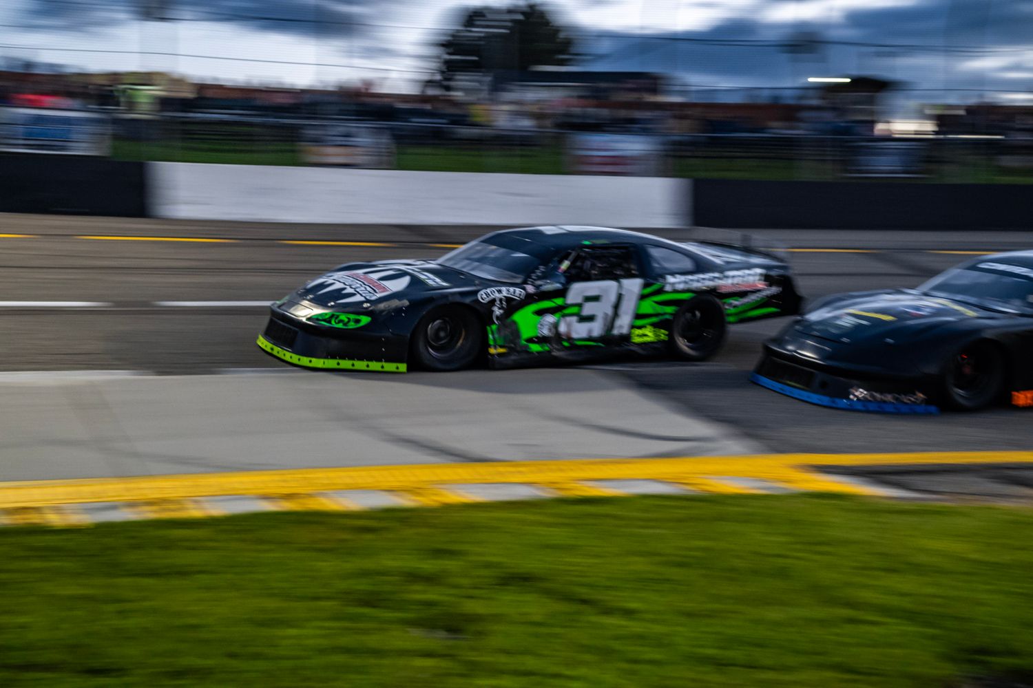 Race cars speeding around a track during a motorsport competition.