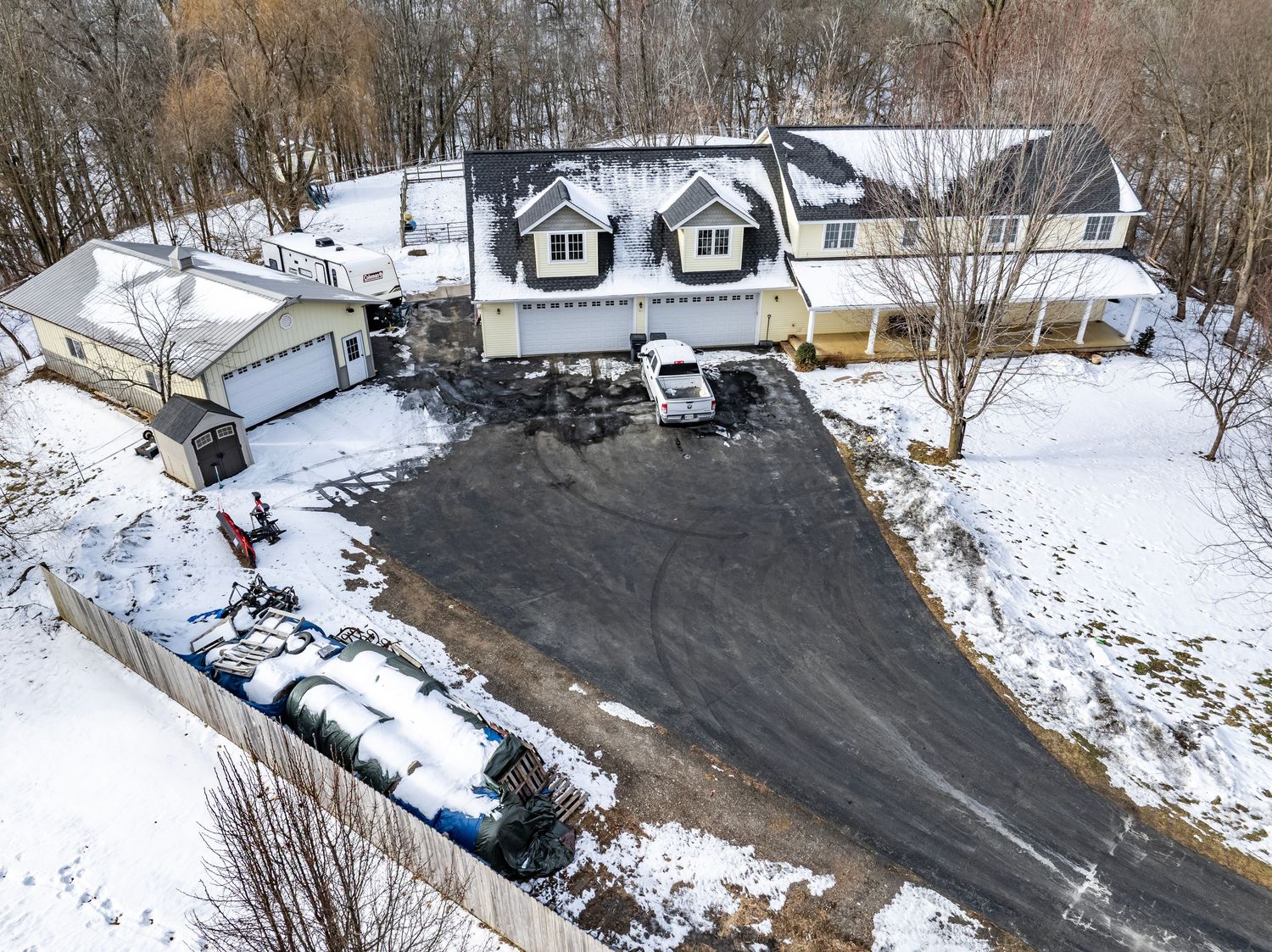 Aerial winter view of a residential property with snow covered driveway.