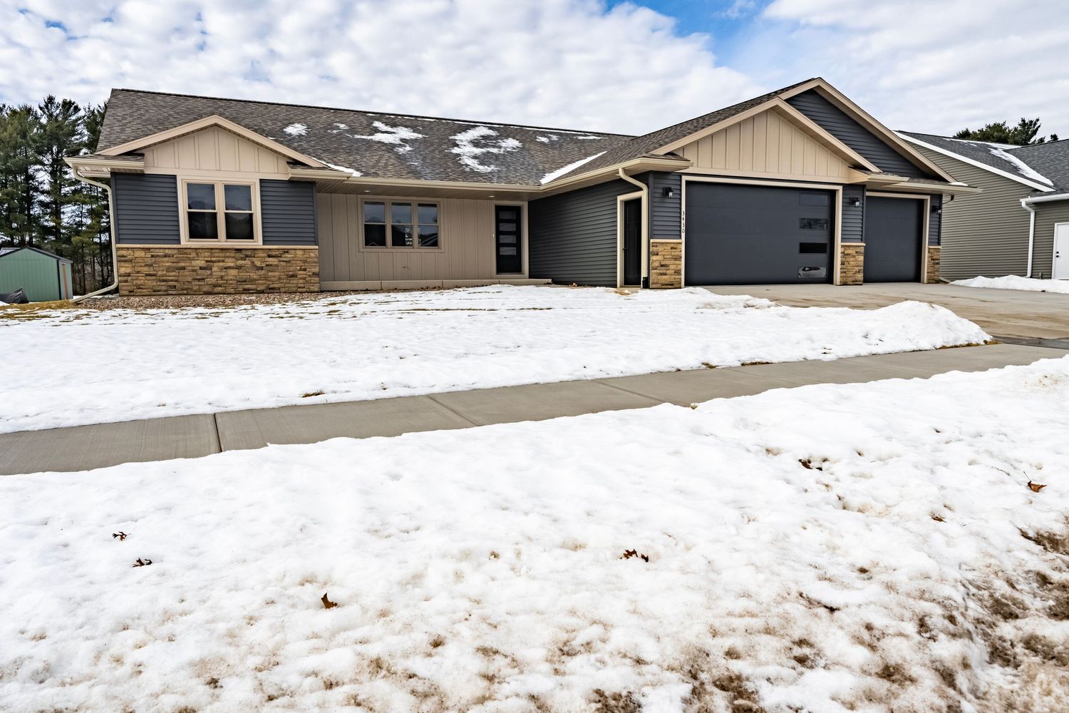 Snow covered exterior view of a modern residential home with attached garage.