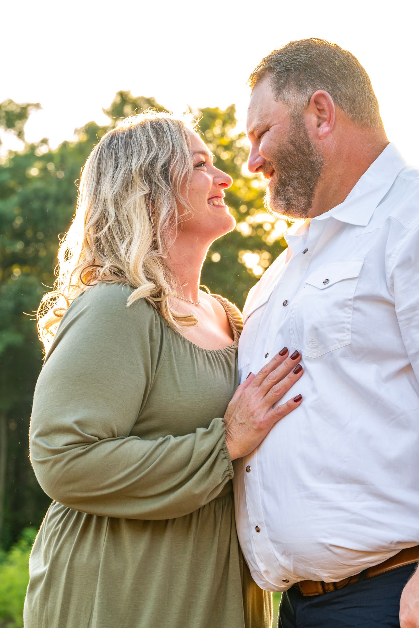 Sweet candid moments captured between couple during outdoor photo session at sunset.