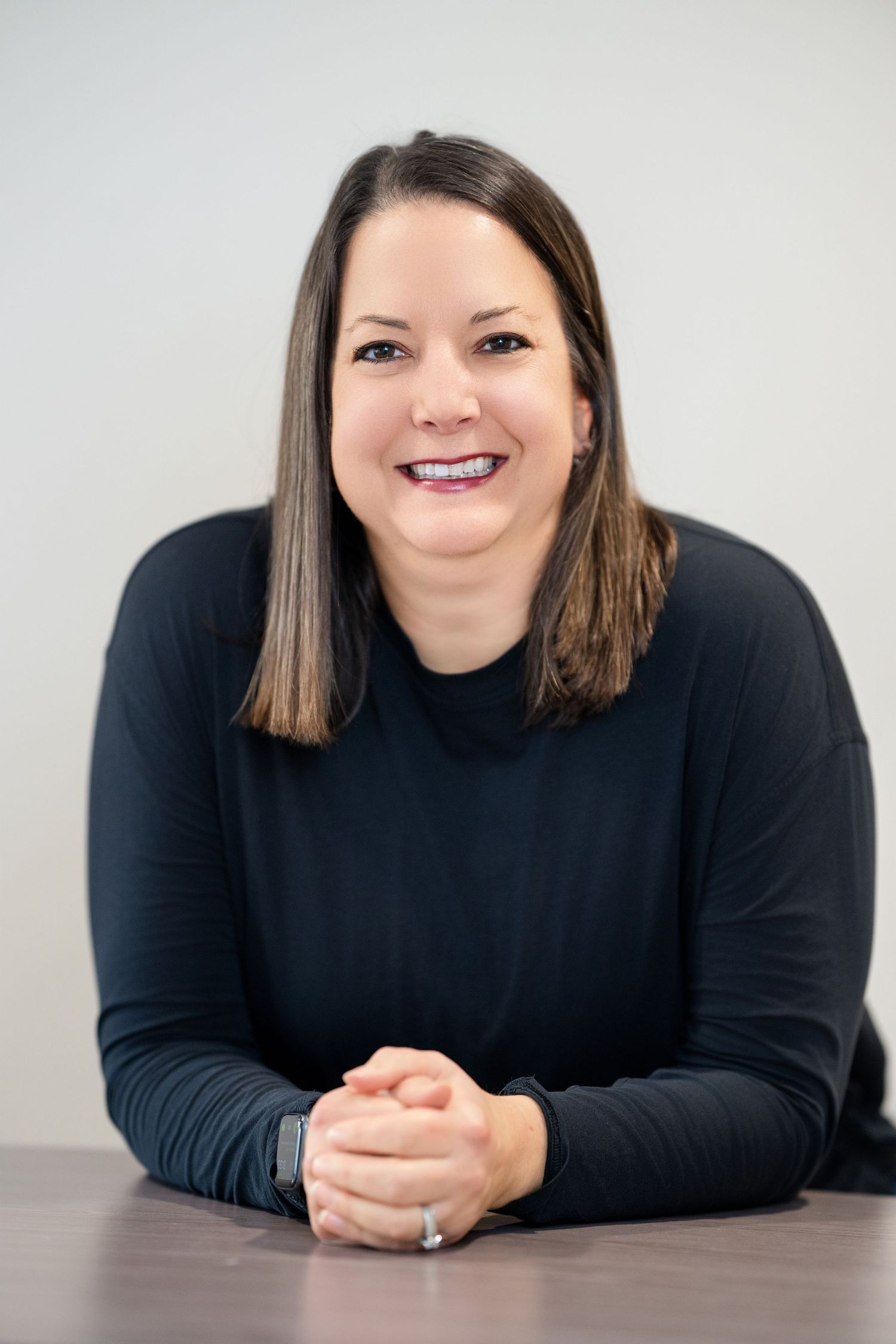 Professional headshots showing a person in black attire against a white background in various poses.