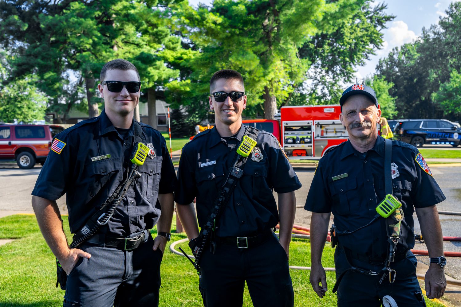 Police officers in uniform standing together at an outdoor community event.