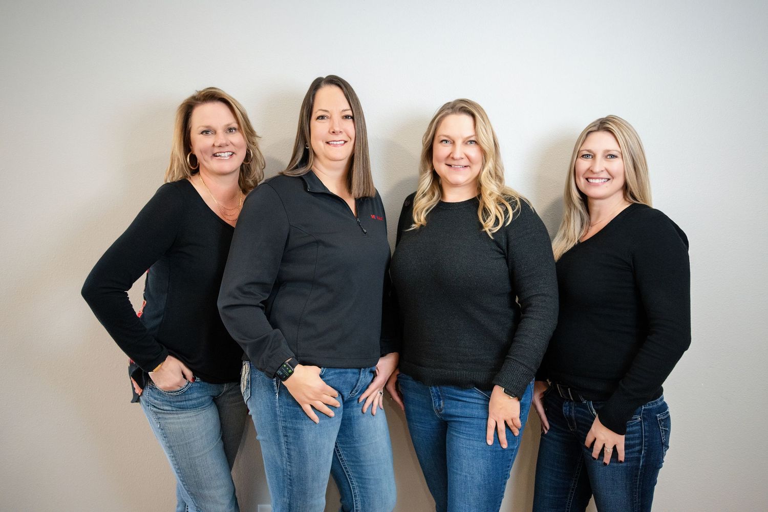Group photo series of team members in coordinated black tops and jeans against white backdrop.