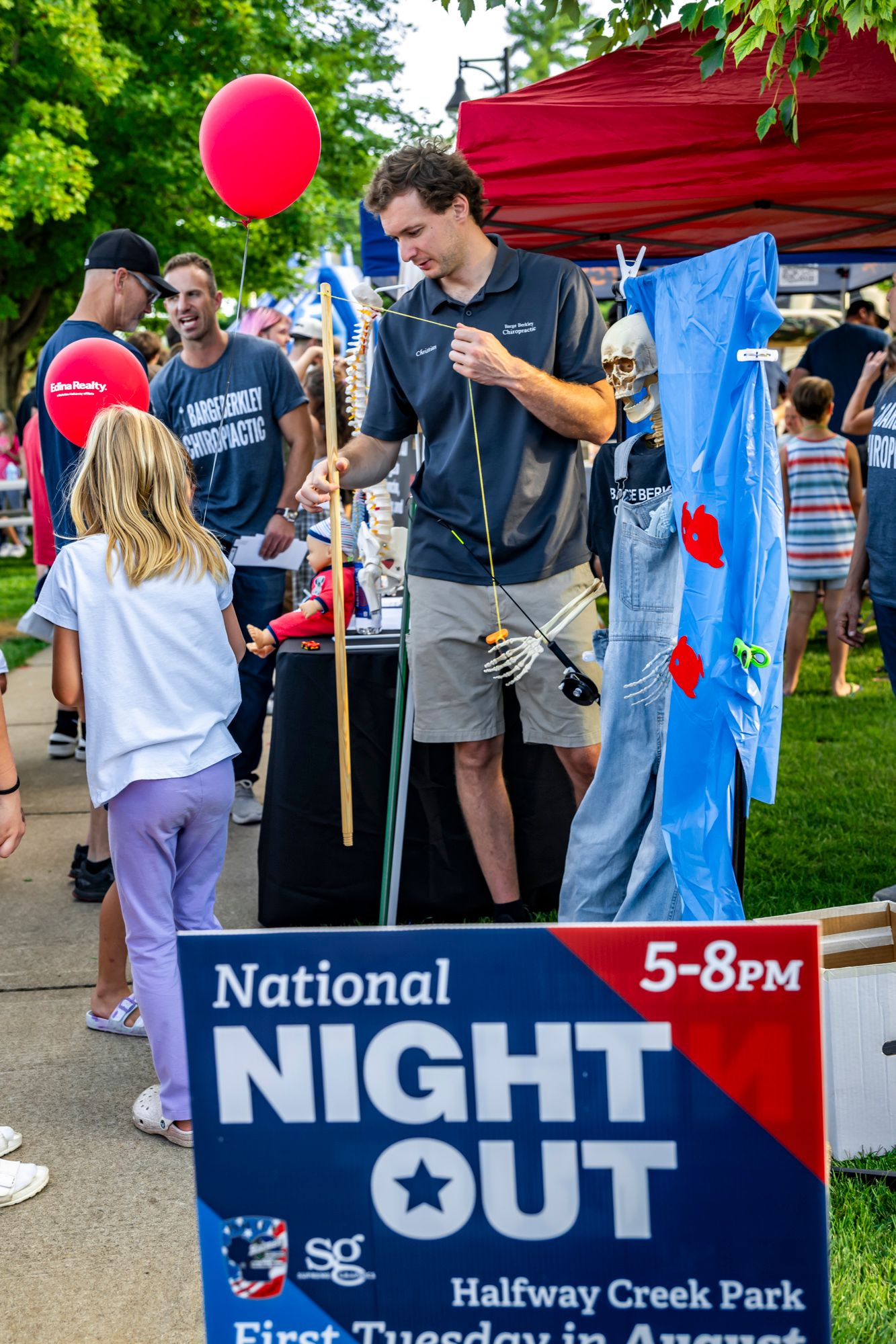 National Night Out event signage and volunteers in blue shirts at a community gathering.