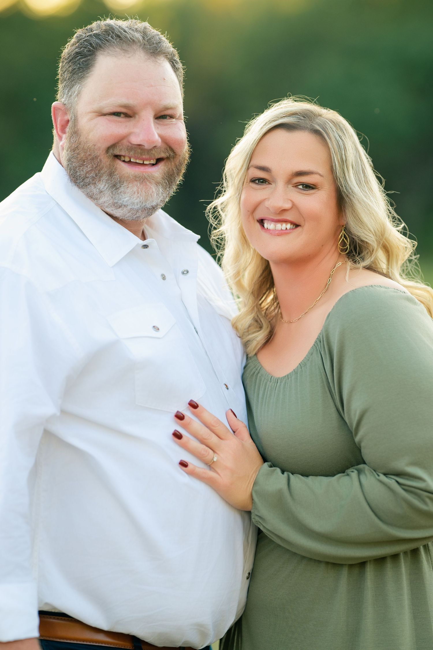 Joyful outdoor portrait session with couple laughing and embracing in warm evening light.