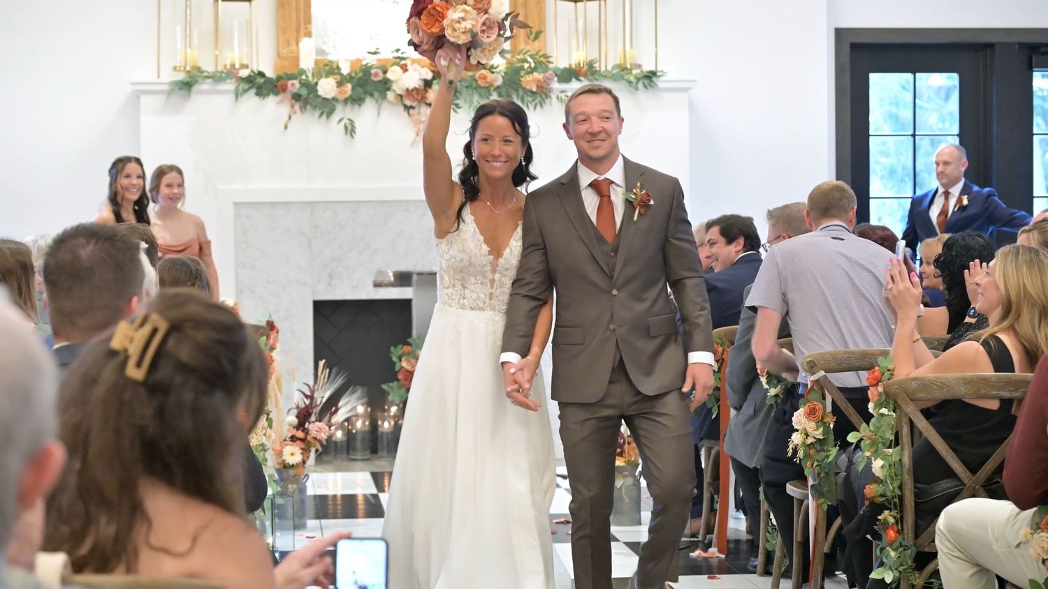 Wedding guests celebrate on a dance floor with string lights overhead during an evening reception.