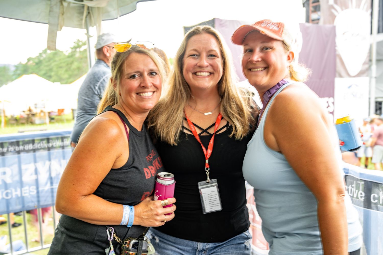 Group of festival-goers smiling and enjoying themselves at an outdoor event.