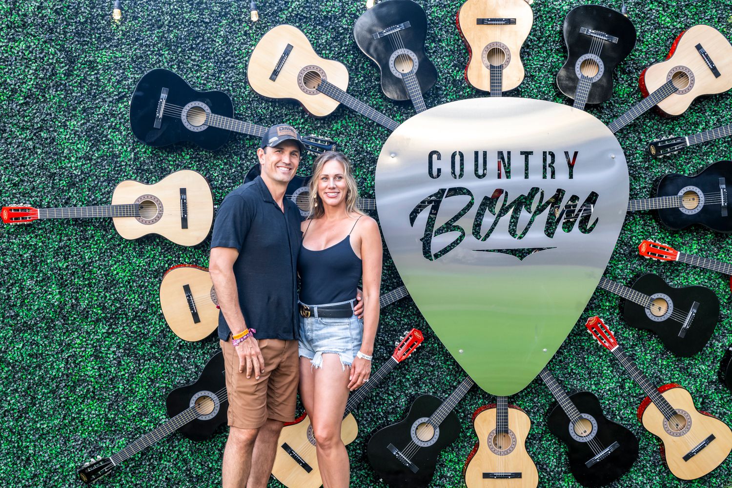 Guitar pick photo backdrop with acoustic guitars arranged in a circle at Country Boom festival.