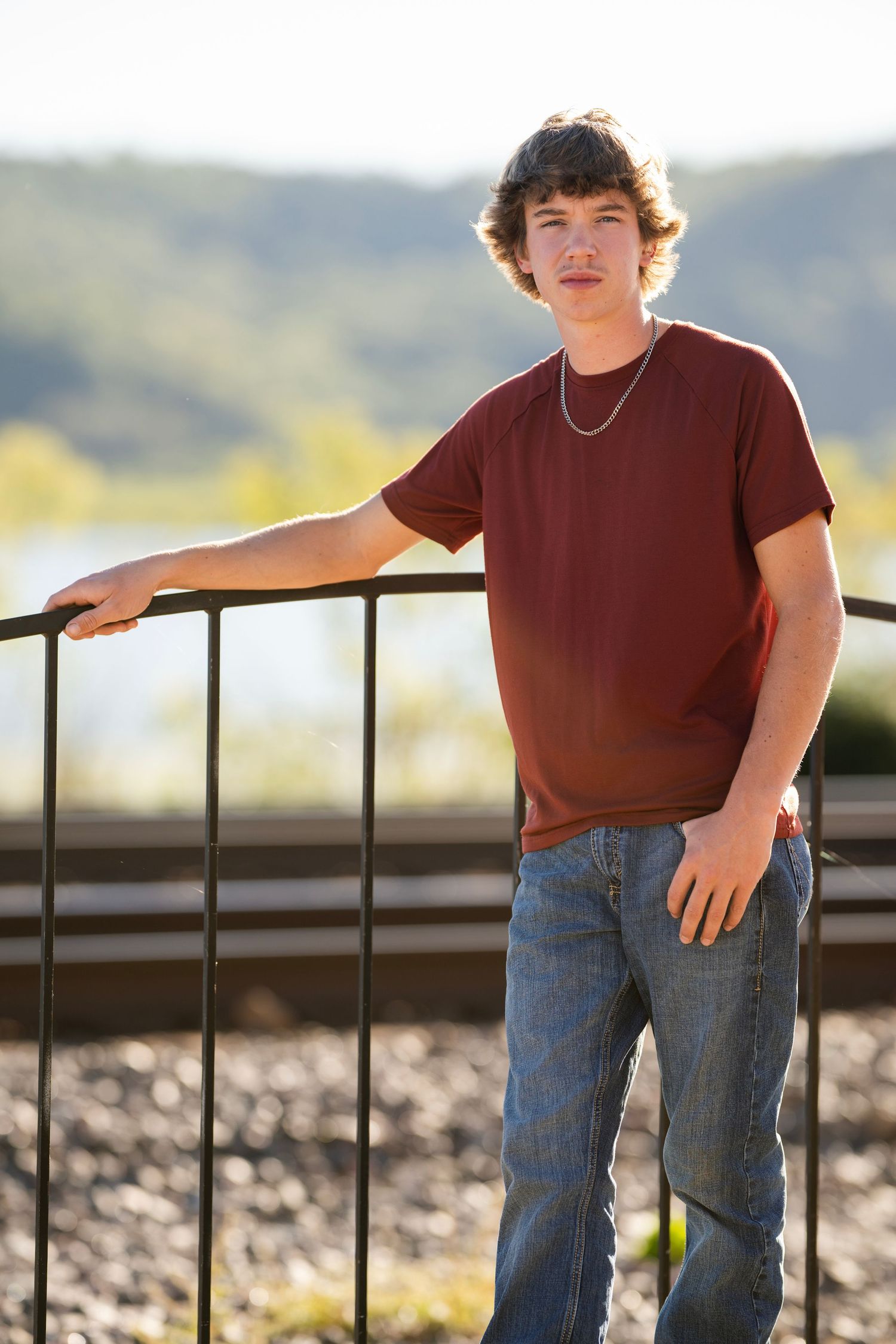 Outdoor portrait series with someone leaning on a railing at sunset.