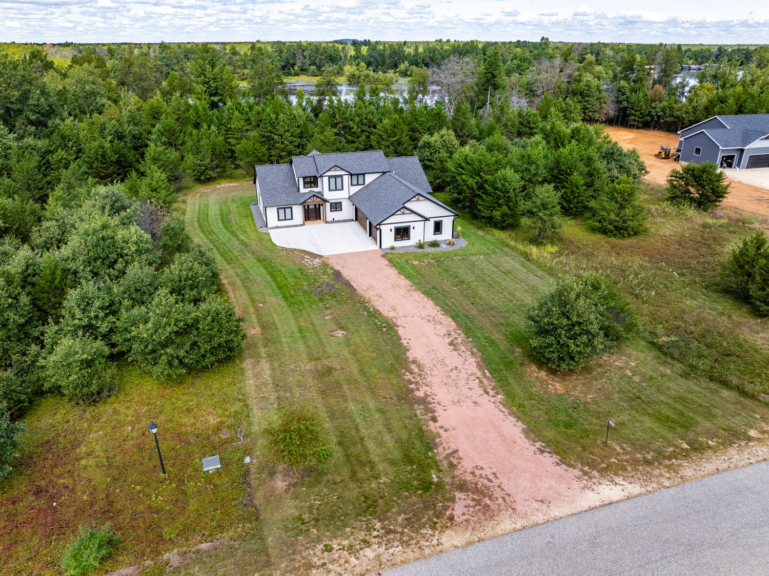 Aerial panorama of a residential neighborhood with winding roads and green lawns.