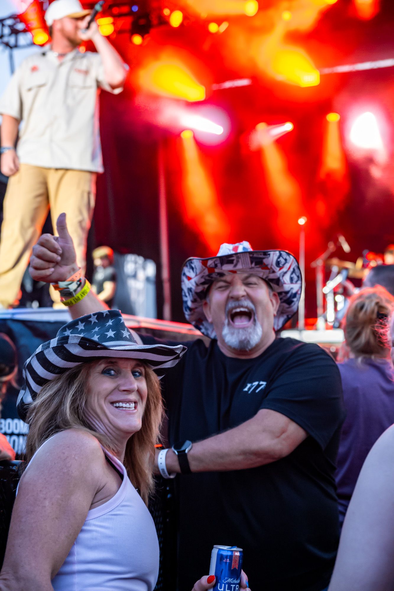 Concert crowd enjoying live music performance with bright red stage lighting effects.