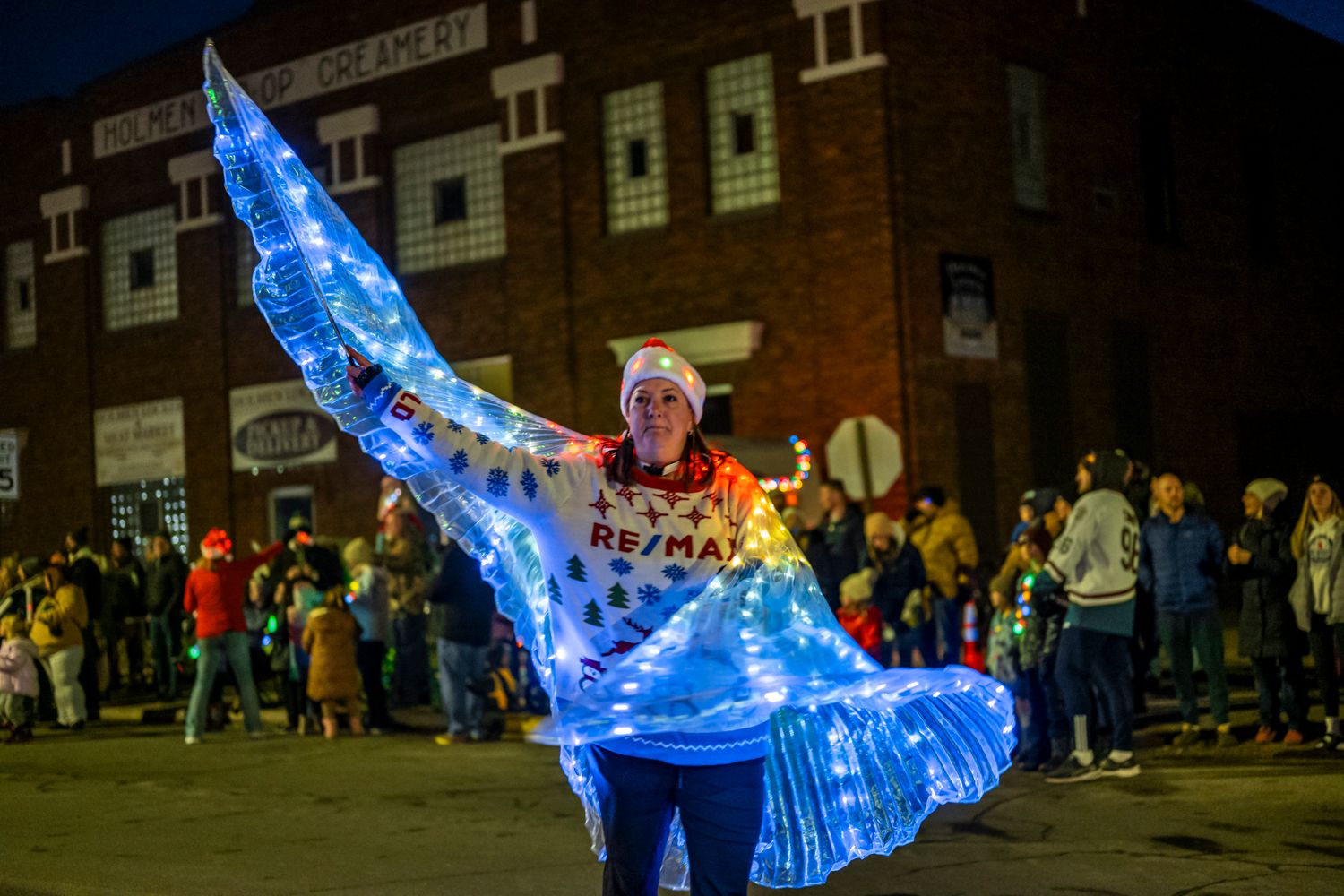 Illuminated blue whale balloon display during nighttime street festival.