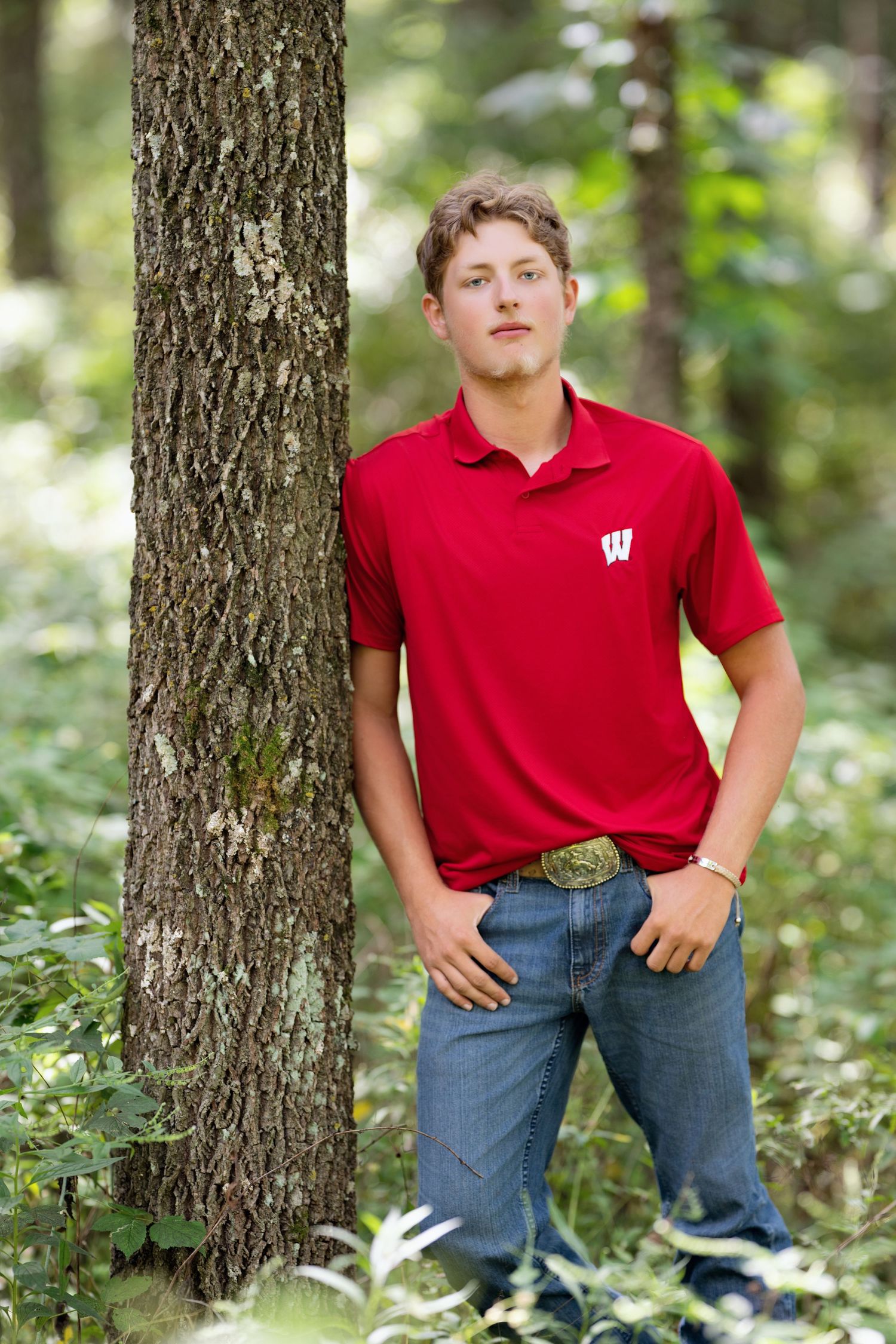 Portrait session in a wooded setting with trees and greenery.