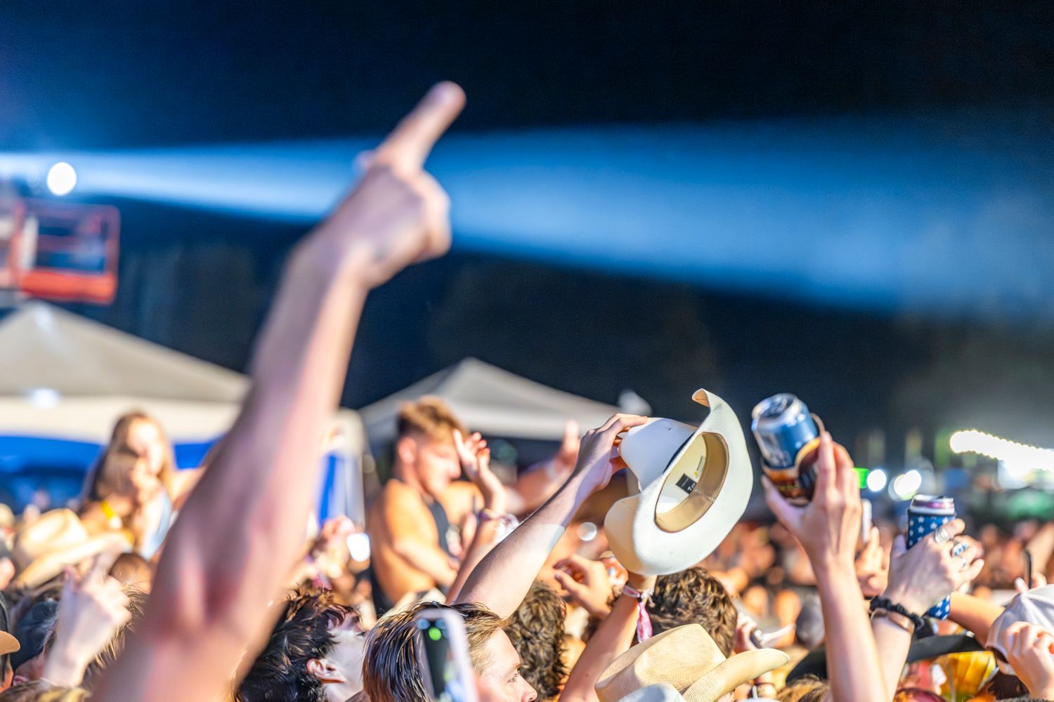 Large concert audience with hands in the air during a nighttime performance.