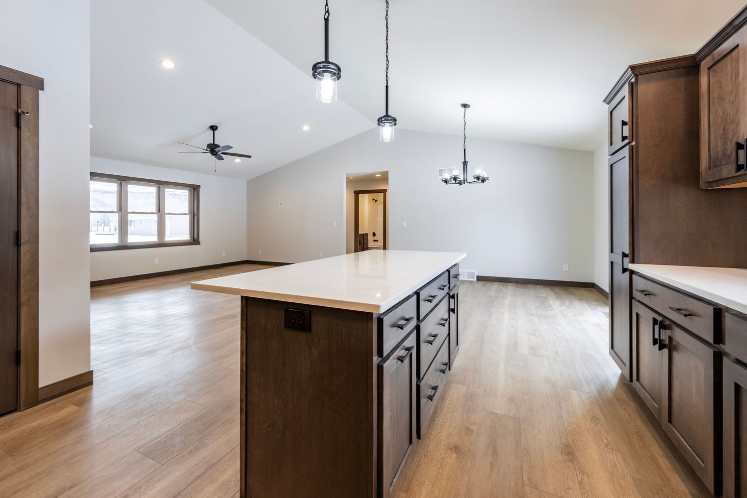 Modern open concept living space with hardwood floors and pendant lighting.