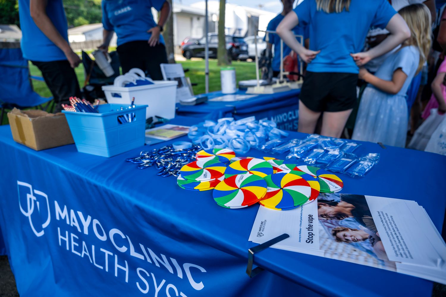 Blue information booths with healthcare organizations at a community fair.