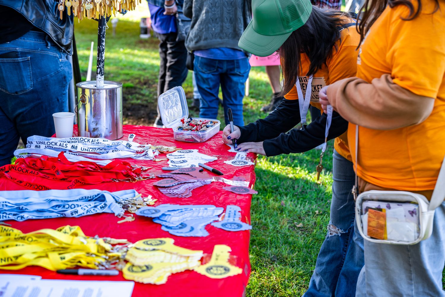 Outdoor event setup with tables displaying merchandise and information materials.