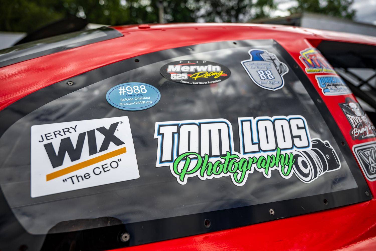 Close-up view of racing sponsor decals and logos on a race car's exterior.