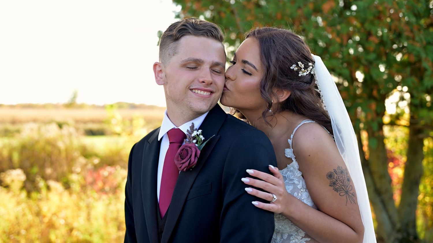 Romantic sunset moment captured at an outdoor wedding venue with rolling hills.
