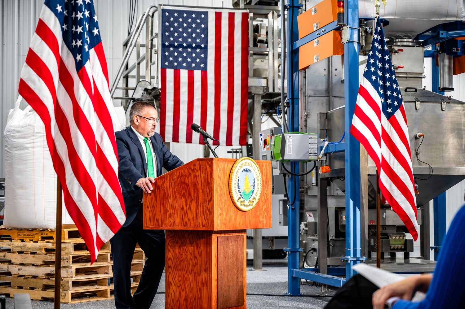 Government or corporate event space with multiple American flags and speaking podium arrangement.