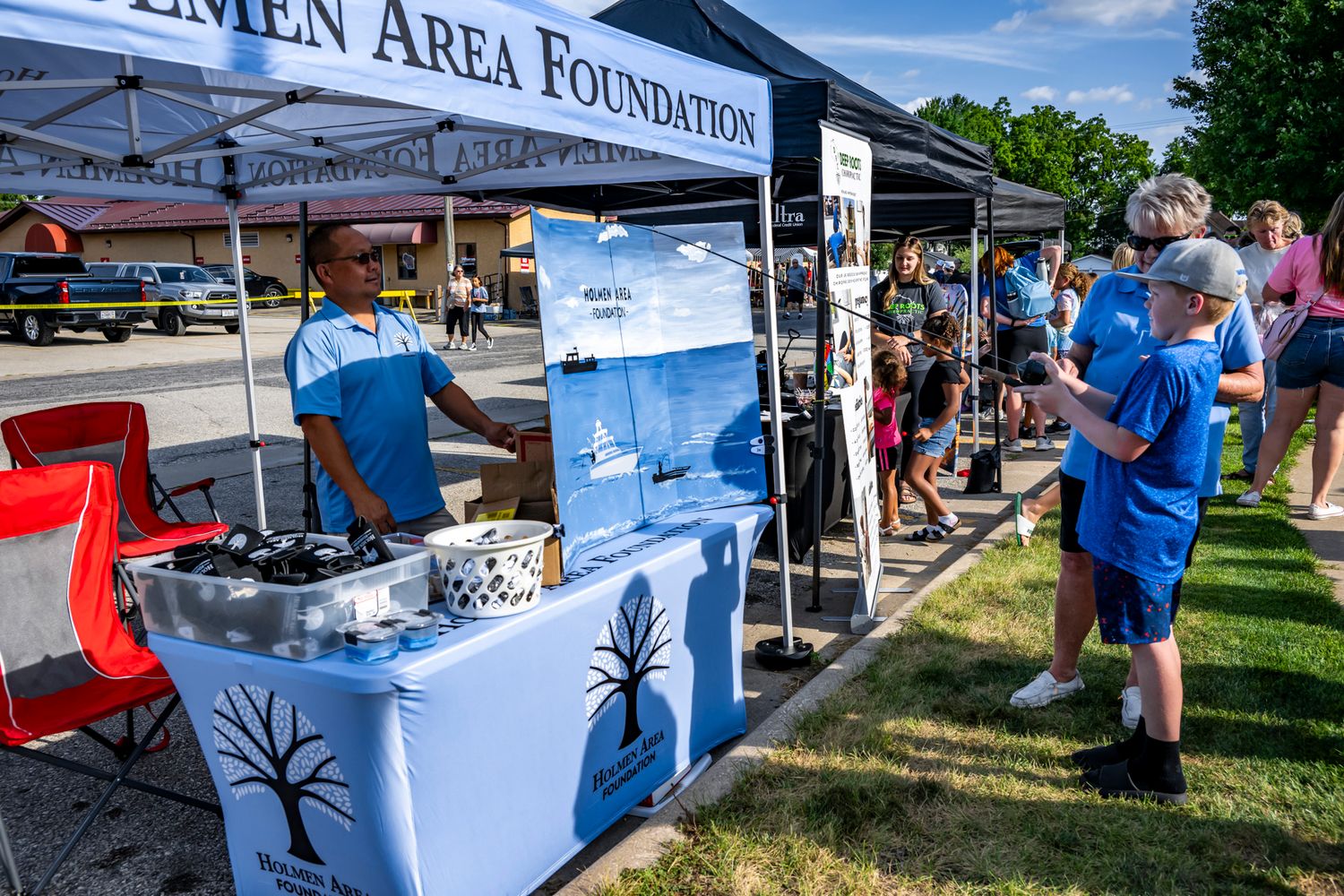 Foundation banner and white tents set up at an outdoor community gathering.