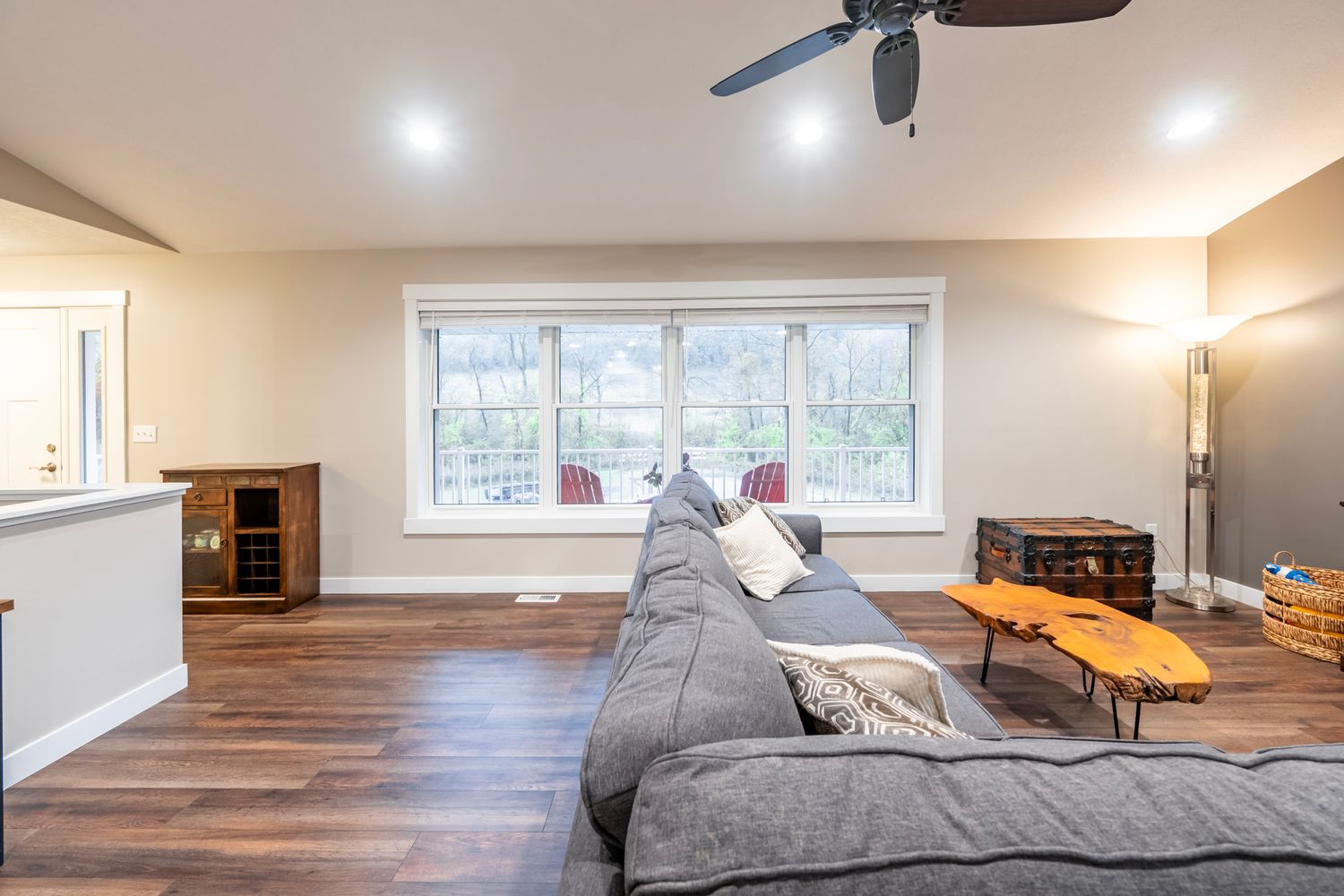 Contemporary living room with recessed lighting, ceiling fan, and hardwood flooring.