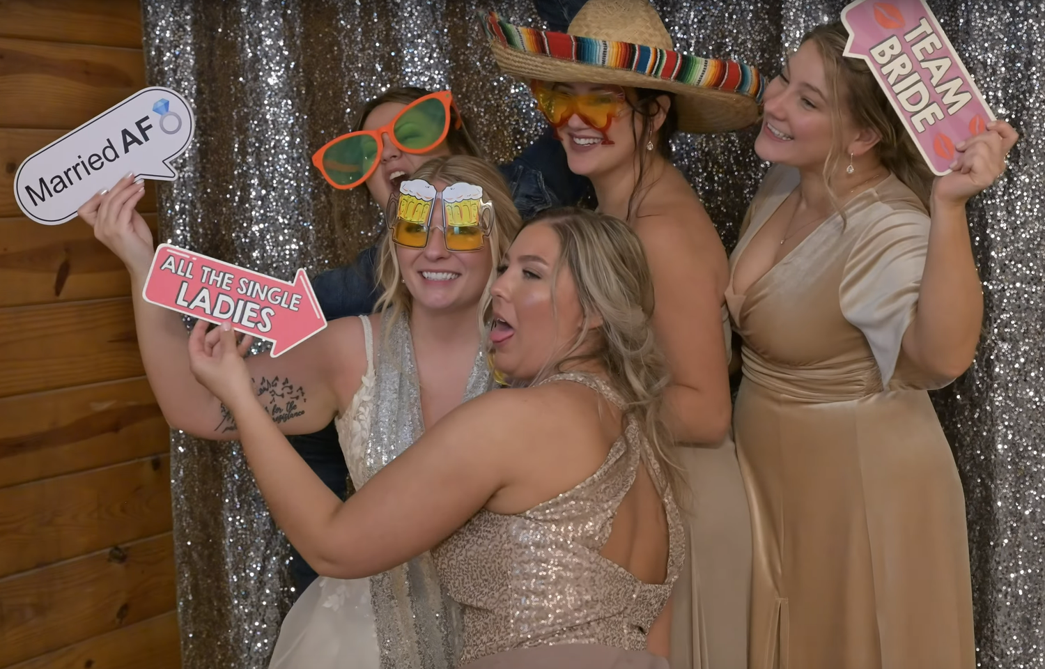 Wedding reception photo booth scene with silver sequin backdrop and props.