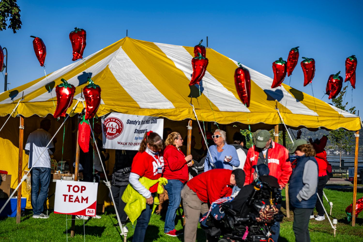 Yellow and white striped tents with red banners at outdoor festival.