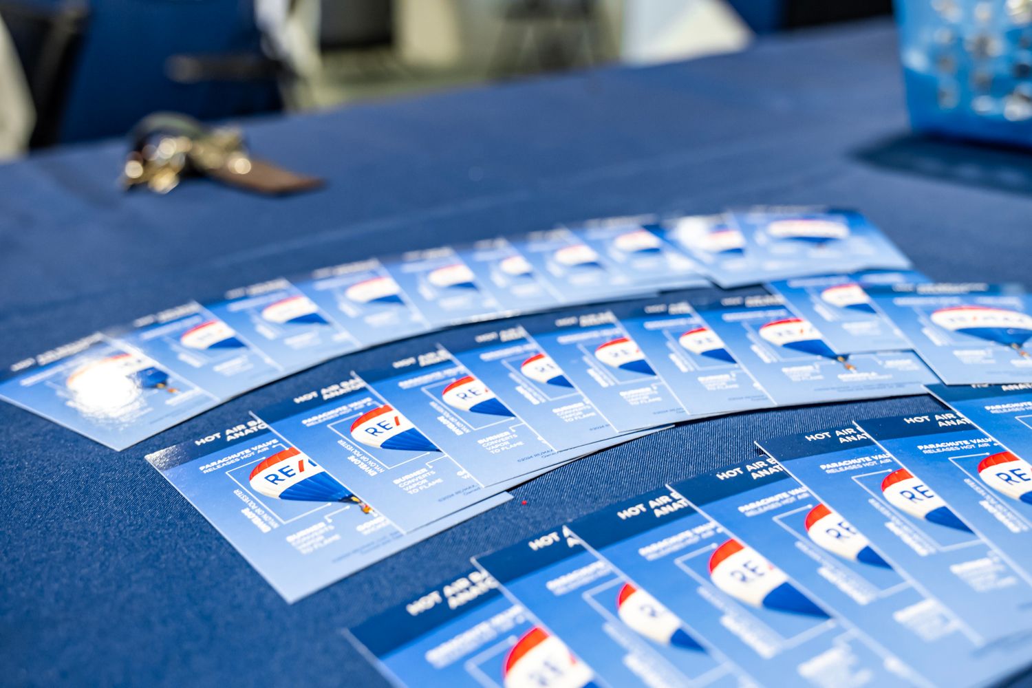 Row of blue branded materials or documents laid out on a dark surface.