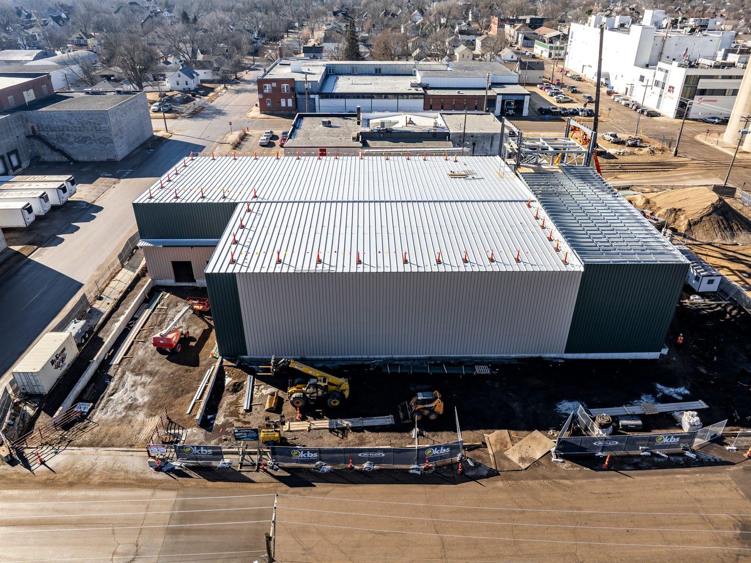 Aerial view of a newly constructed commercial building with metal roofing.