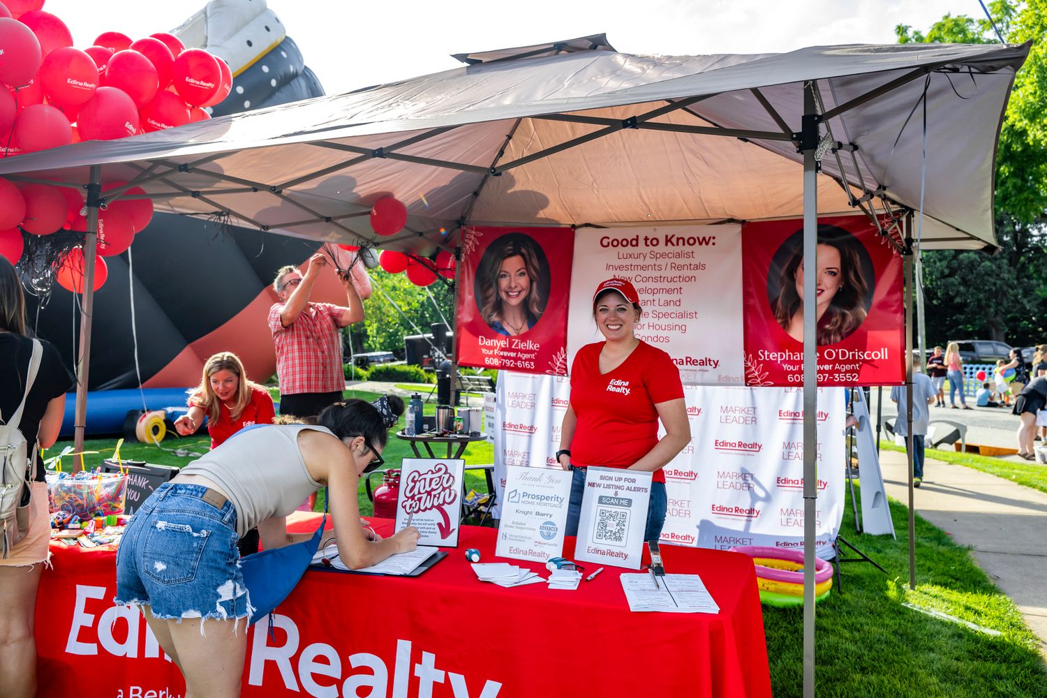 Red and white branded event tent setup with promotional displays and banners.