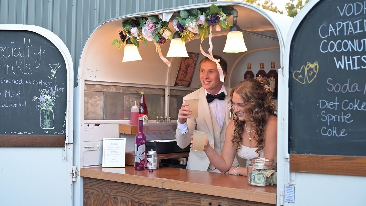Wedding reception venue with chalkboard menu signs and rustic decor.