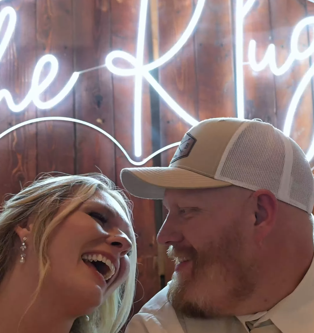 Candid moments between newlyweds under neon lighting at reception venue.