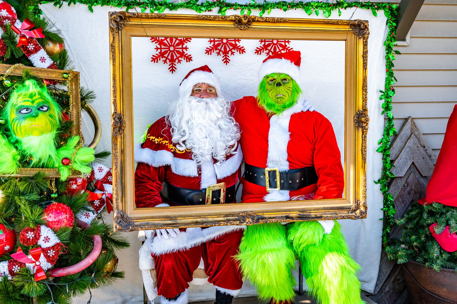 Festive Christmas display featuring a golden frame with Santa Claus surrounded by green decorations and snowflakes.