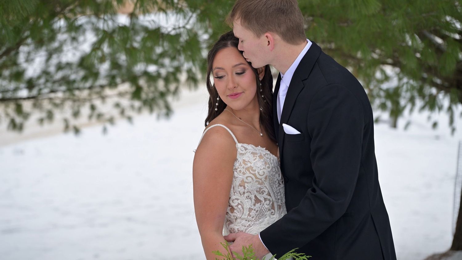 Wedding couple embraces during outdoor winter photo session.