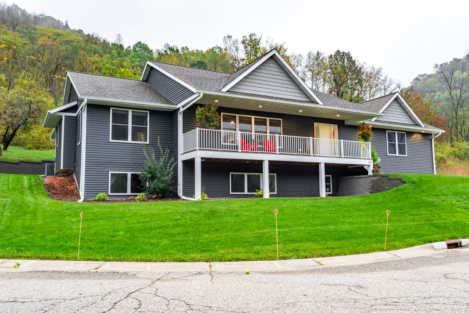 Exterior view of modern gray house with attached garage and landscaped yard.